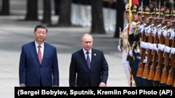 Si Cinpin və Vladimir Putin Pekində fəxri qarovulun önündən keçirlər.