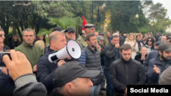 ადგილობრივი მედიის თანახმად, "საპროტესტო აქციაზე ხალხი დილიდან იკრიბებოდა რუსეთისა და აფხაზეთის დროშებით".