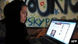 Афганка просматривает Facebook в интернет-кафе в Кабуле до захвата власти талибами в 2021 году