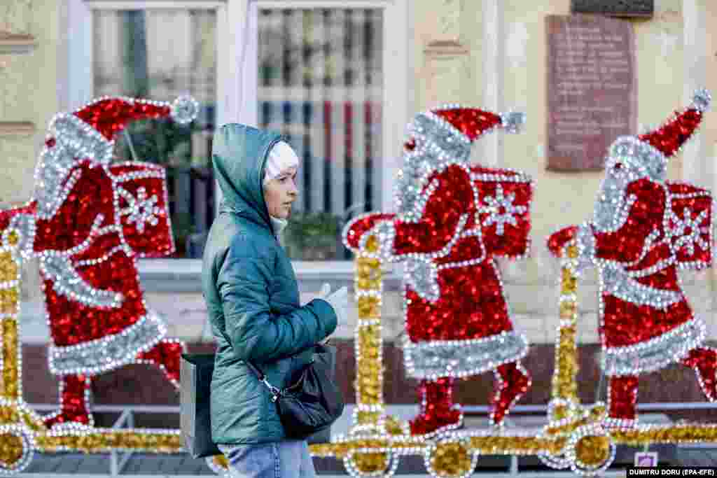 Молдова, Кишинев. Рождество майрамына карата жасалгалардын жанынан өтүп бараткан аял.&nbsp;