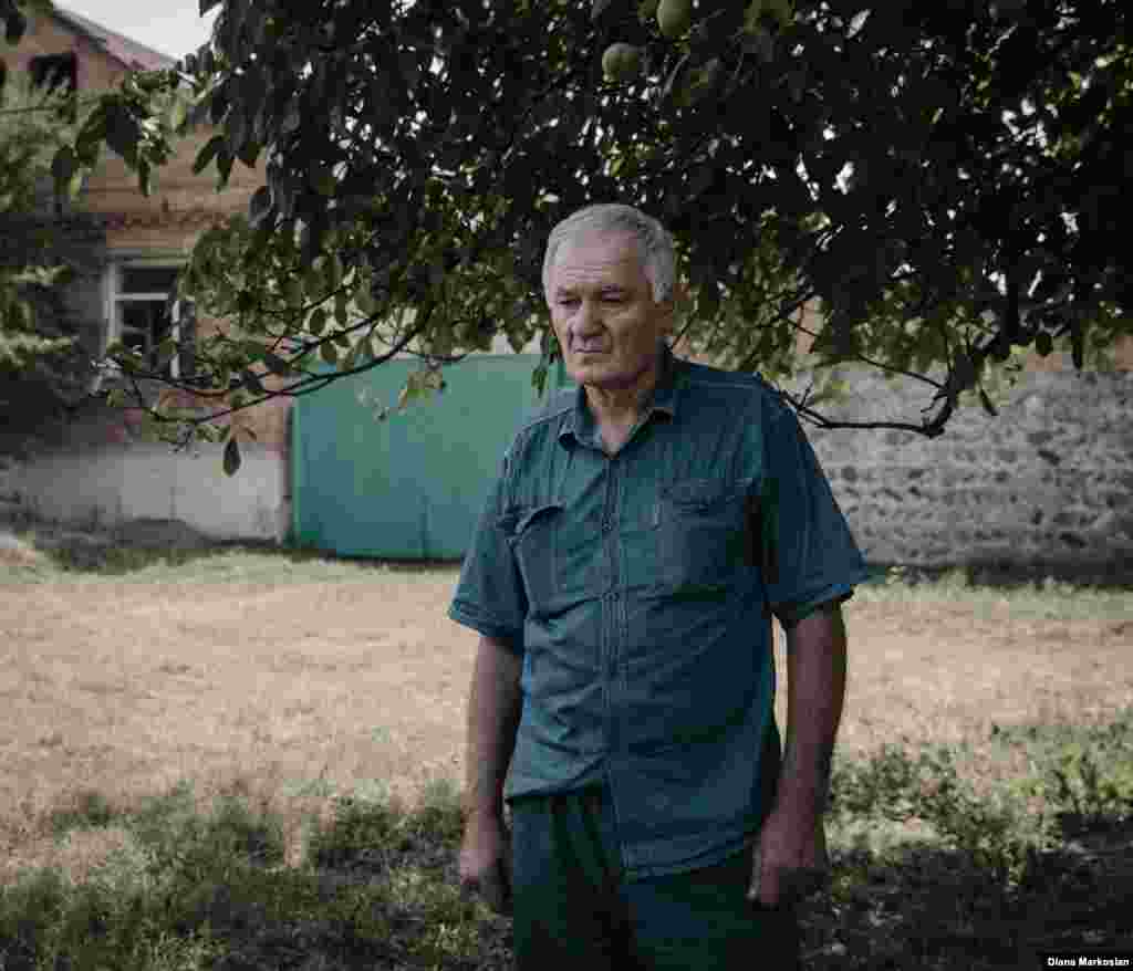 &quot;ისე მგონია, თითქოს ჯერაც ჩვენთან ერთად იყოს&ldquo; - ამბობს 63 წლის რუსლან კოკოვი. როდესაც ოქსანა წავიდა სკოლაში რათა აღარასოდეს დაბრუნებულიყო, რუსლანი ბაზარში იყო. მის დაბადების დღეს რუსლანი და მისი 27 წლის ვაჟი ურუზმაგი მისთვის ყოველთვის ტოვებენ მაგიდასთან ერთ ადგილს. ისინი მიირთმევენ მის საყვარელ საჭმელს - საზამთროს, ხურმას, წითელ ფორთოხალს. ამ ფოტოზე რუსლანი გადაღებულია საკუთარი სახლის ფონზე კომინტერნის ქუჩაზე. სკოლა №1 მისი ოთახის ფანჯრიდან მოჩანს. ალყის დროს აქ რუსეთის სპეცსამსახურების შენაერთები იყო განთავსებული. დამაბოლოებელი სროლის დროს მისი სახლის ორი ფანჯრის მინები ჩაიმსხვრა. გასული ათი წლის განმავლობაში მან ვერა და ვერ მოკრიბა ძალა მათ შესაკეთებლად. &quot;როდესაც რაიმე მაგონებს ამ საშინელ ტრაგედიას, უბრალოდ ძალიან ვდარდობ&quot;, - ამბობს ის.