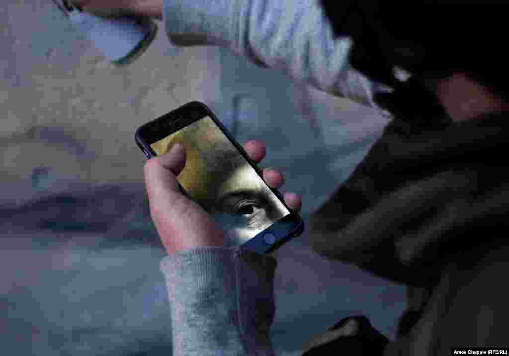 Ван Хелтен суретті смартфонындағы фотоға қарап отырып салады.&nbsp;