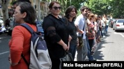 Около ста студентов и преподавателей в знак протеста, взявшись за руки, выстроились в живую цепь на разделительной линии проезжей части в центре Тбилиси