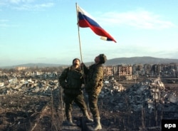 Російські солдати піднімають прапор Росії над вщент зруйнованим Грозним. Лютий 2009 року