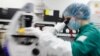 A scientist examines COVID-19 infected cells under a microscope during research for a vaccine at a laboratory of BIOCAD biotechnology company in St. Petersburg, Russia, on May 20.