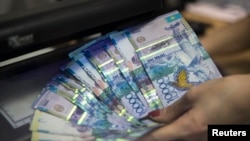 Алматыдагы Евразия банкында кассир теңге санап жатат. 15-январь, 2015-жыл.
