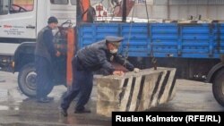 Милиция кызматкерлери шаардын кире беришине блокпостторду орнотуп жатат. Жалал-Абад шаары. 21-март, 2020-жыл.