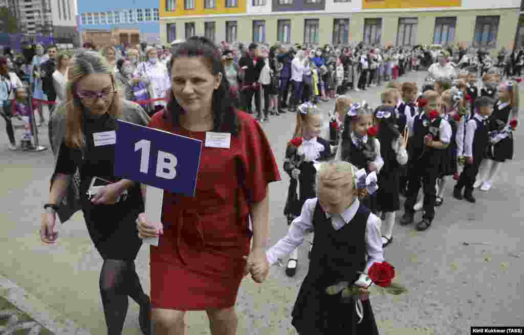 პირველკლასელები სასწავლო წლის დაწყების ცერემონიაზე ნოვოსიბირსკის 218-ე სკოლაში. რუსეთში 17 მილიონი მოსწავლე უბრუნდება საკლასო ოთახებს. პირბადეები არ არის სავალდებულო, მაგრამ ხელისუფლებამ უსაფრთხოების ზოგი სხვა ზომა შემოიღო.