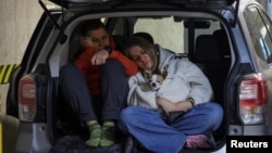 Oameni, adăpostindu-se într-o parcare subterană în timpul atacului rusesc dein noaptea de sâmbătă spre duminică, la Lvov