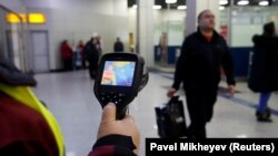 Сотрудница международного аэропорта Алматы с тепловизором. Архивное фото. 