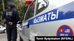 Қызмет көлігі жанында тұрған милиция өкілі. (Көрнекі сурет.)