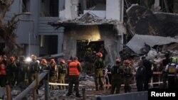 Куткаруу топтору Израилге болгон чабуулда кыйраган үйдүн урандыларын тазалап жатат.