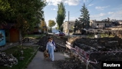 A 25 éves Darka Harnik megsimogat egy kóbor kutyát az egyik utcán Kramatorszkban 2025. szeptember 10-én